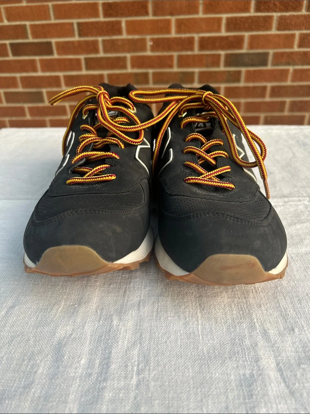 New Balance Men’s Black Sneakers with Tan Sole and Yellow-Orange Laces